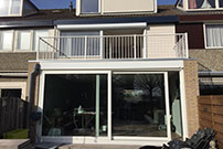 Uitbouw met glazen dak kunststof kozijnen met openslaande deuren standaard breedte en diepte. In principe vergunningsvrij tot 250cm diepte aan achterzijde woning