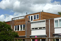 Opbouw op plat dak van cedarhout en kunststof kozijnen tevens de voorgevel bekleed met cedarhout en nieuwe kunststof kozijnen aangebracht
