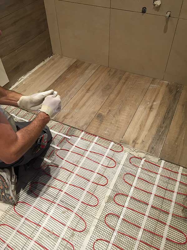 Badkamer met hout-look tegels op elektrische vloer-verwarming mooi gecombineerd met een zandkleurige wandtegel de douche-hoek is nu waar zich een gangkast bevond