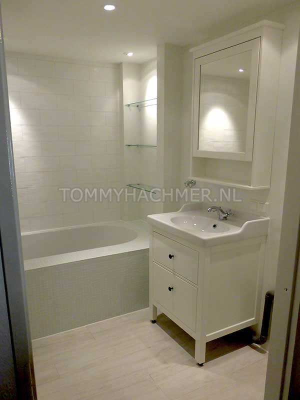 Badkamer met een nis met glazen planchetjes beton cire boven de wandtegels